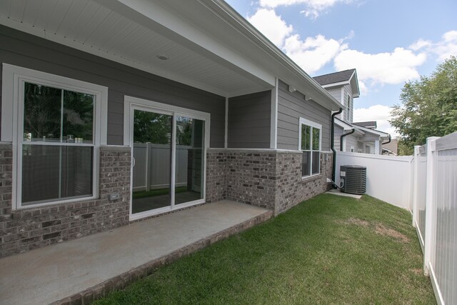 view of side of property featuring a yard, a patio area, and central air condition unit