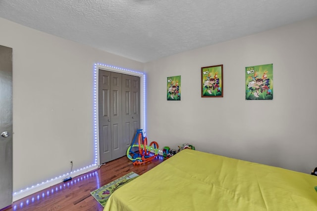 bedroom featuring a closet, wood-type flooring, and a textured ceiling