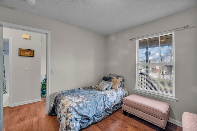 bedroom with light hardwood / wood-style floors and a textured ceiling