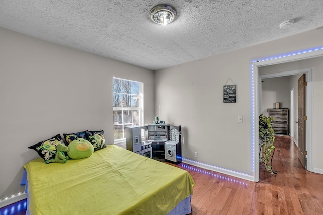 bedroom with a textured ceiling and dark wood-type flooring