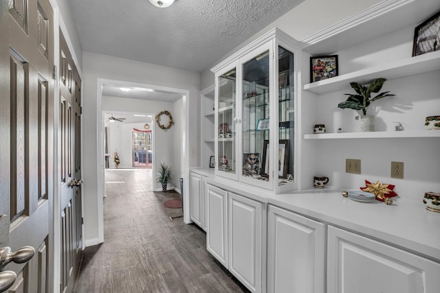 corridor with dark wood-type flooring and a textured ceiling