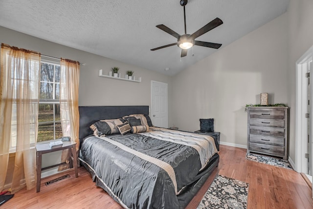 bedroom featuring ceiling fan, wood-type flooring, lofted ceiling, and multiple windows