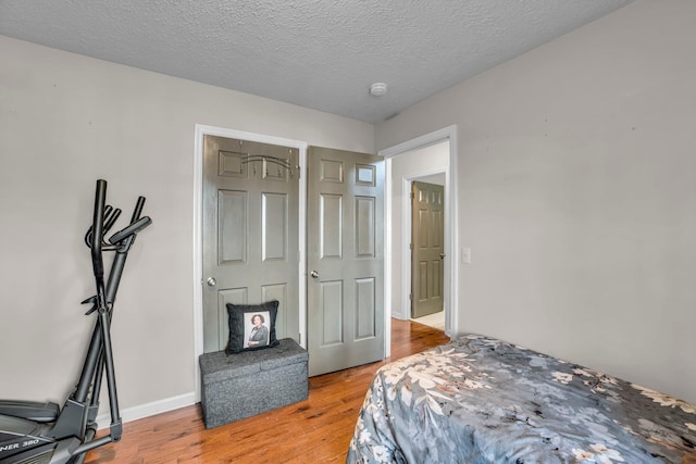 bedroom featuring light hardwood / wood-style floors and a textured ceiling
