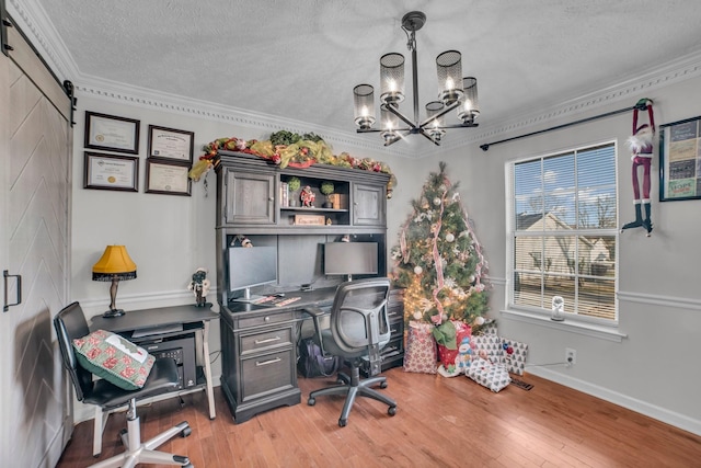 office space with ornamental molding, a textured ceiling, a barn door, hardwood / wood-style flooring, and a chandelier