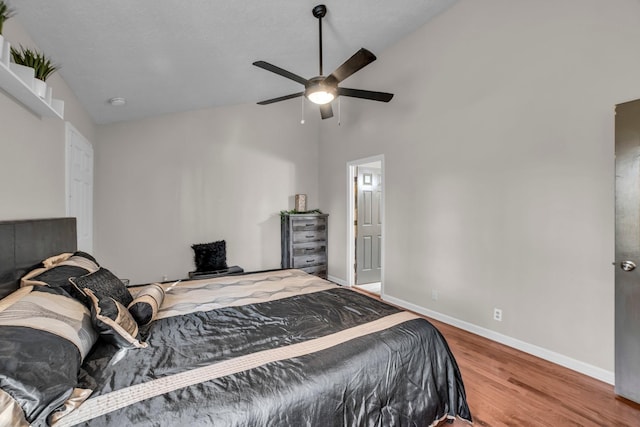 bedroom featuring hardwood / wood-style flooring, high vaulted ceiling, and ceiling fan