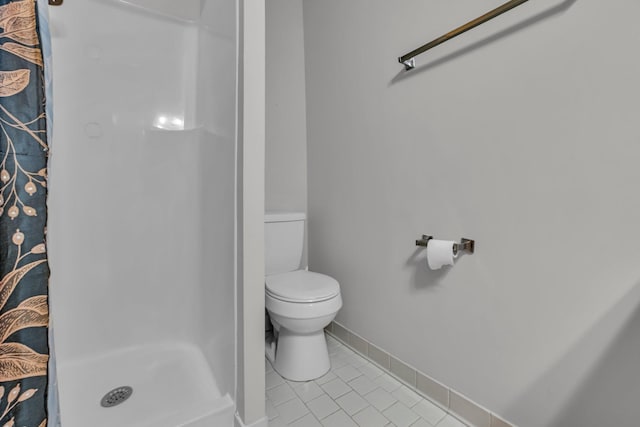 bathroom with tile patterned floors, toilet, and walk in shower
