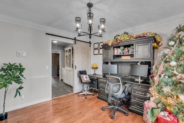office space featuring a textured ceiling, crown molding, wood-type flooring, a barn door, and an inviting chandelier