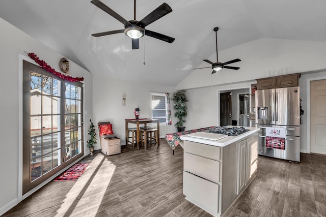 kitchen featuring stainless steel fridge, a center island, vaulted ceiling, and a wealth of natural light