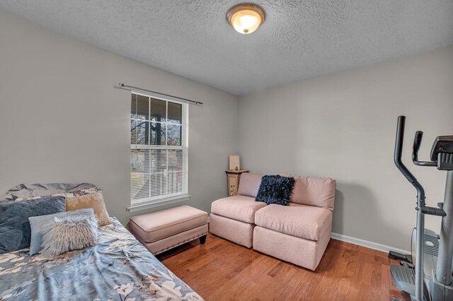 bedroom featuring hardwood / wood-style floors and a textured ceiling