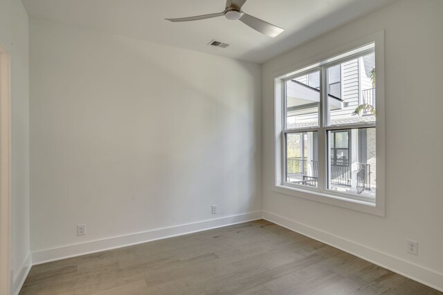 unfurnished room featuring light hardwood / wood-style floors, a wealth of natural light, and ceiling fan