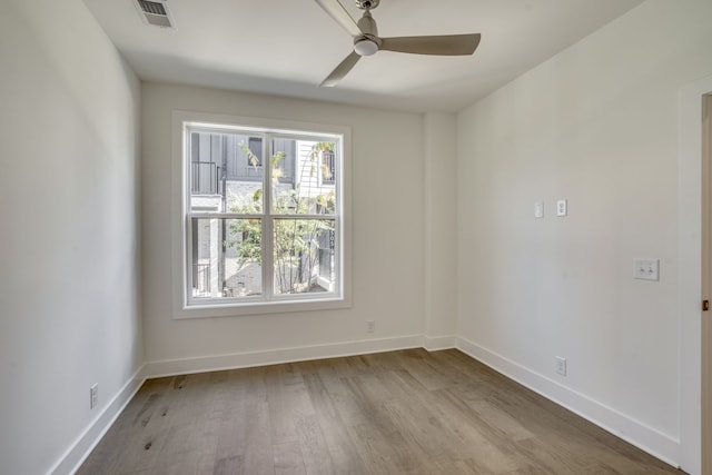 empty room with ceiling fan and light hardwood / wood-style flooring