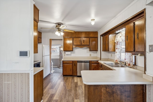 kitchen with sink, dark hardwood / wood-style flooring, stainless steel dishwasher, kitchen peninsula, and ornamental molding