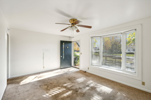 carpeted spare room with ceiling fan and a healthy amount of sunlight