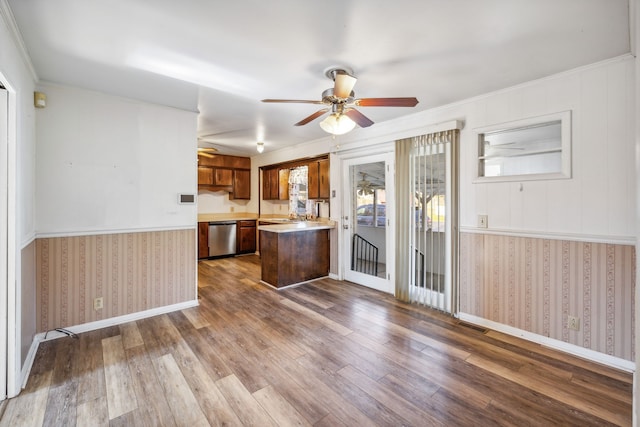 kitchen featuring hardwood / wood-style floors, stainless steel dishwasher, ceiling fan, ornamental molding, and kitchen peninsula