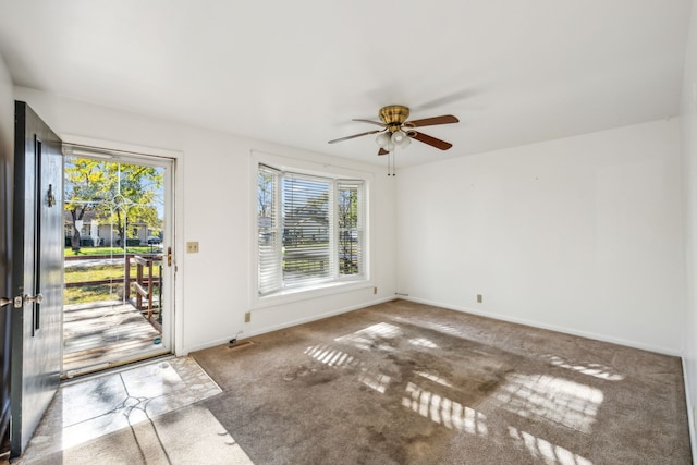 foyer entrance with ceiling fan and carpet floors