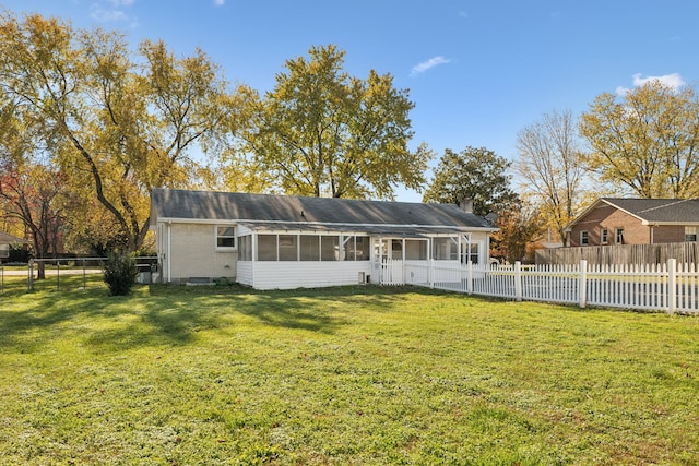 rear view of property with a sunroom and a yard