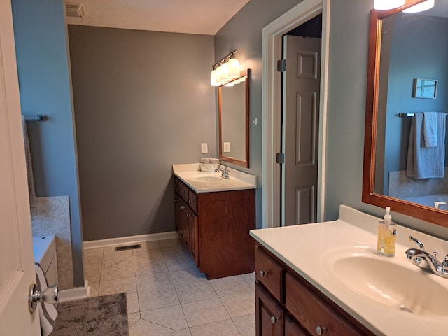 bathroom with vanity, tile patterned flooring, and a bathing tub