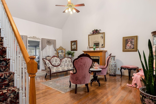 living area featuring ceiling fan, wood-type flooring, and high vaulted ceiling