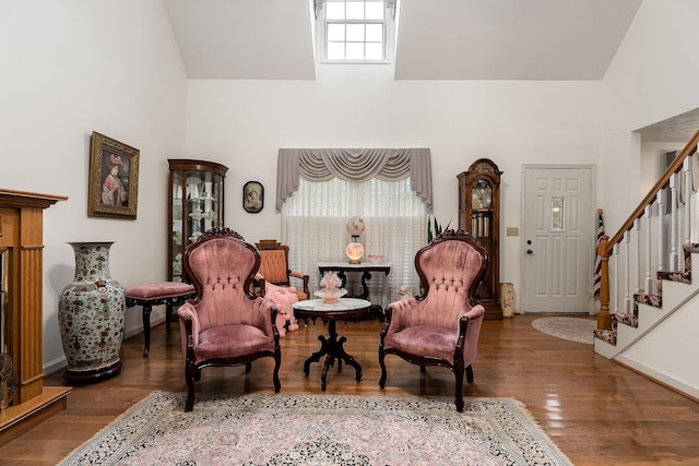 living area with high vaulted ceiling and wood-type flooring