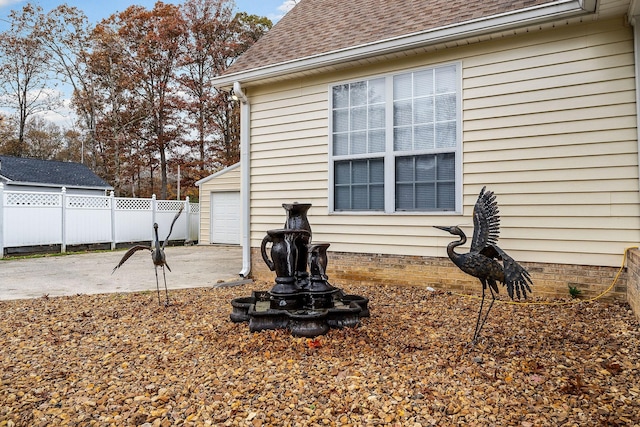 view of side of property featuring a patio and a garage