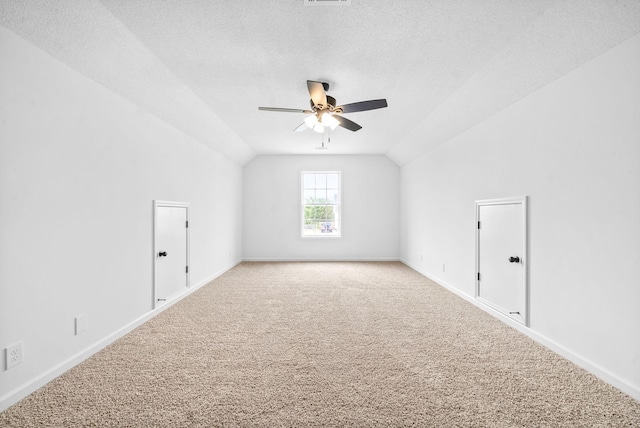 additional living space with carpet, ceiling fan, a textured ceiling, and vaulted ceiling