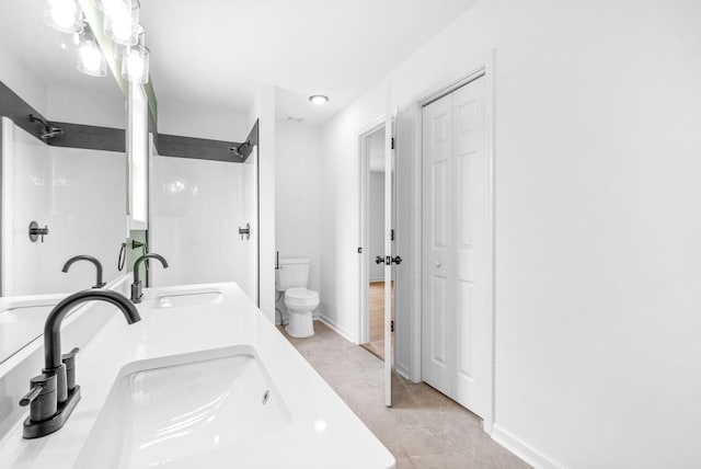 bathroom featuring tile patterned flooring, vanity, toilet, and walk in shower