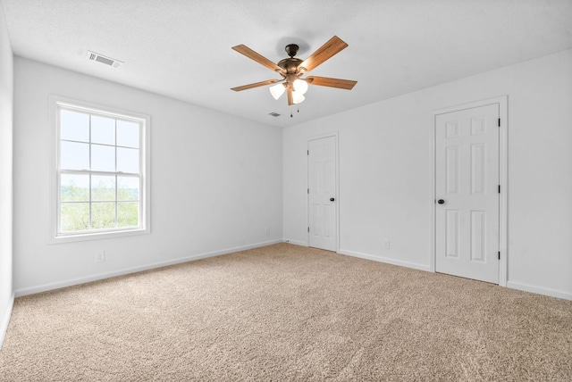 carpeted spare room featuring ceiling fan