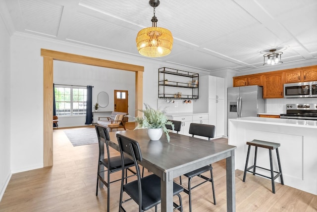 dining room with a chandelier, light wood-type flooring, and crown molding