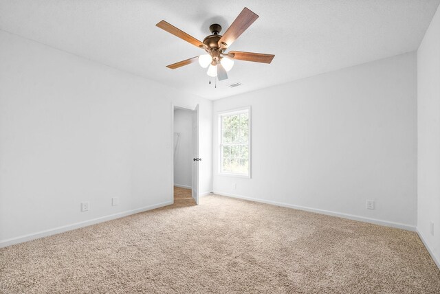 unfurnished room with ceiling fan and carpet