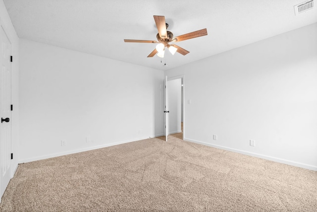 spare room with ceiling fan and carpet