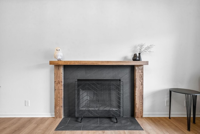 interior details with wood-type flooring and a fireplace