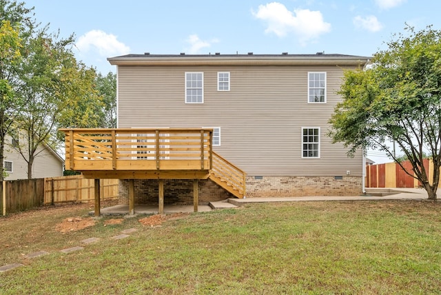 rear view of house featuring a wooden deck and a yard