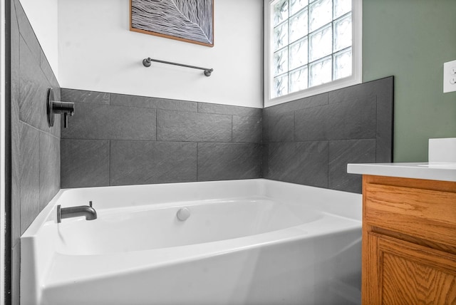 bathroom featuring vanity and a tub to relax in