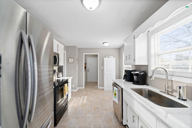 kitchen featuring sink, white cabinets, stainless steel appliances, and light wood-type flooring