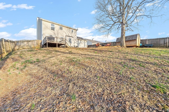 view of yard featuring a wooden deck and a storage unit