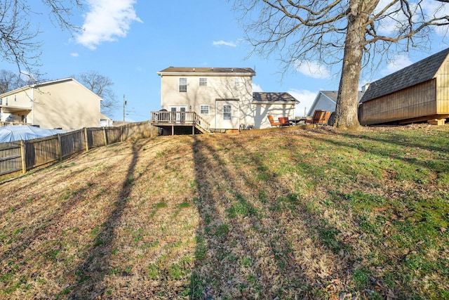 back of property featuring a lawn and a wooden deck