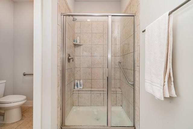 bathroom with tile patterned flooring, toilet, and walk in shower