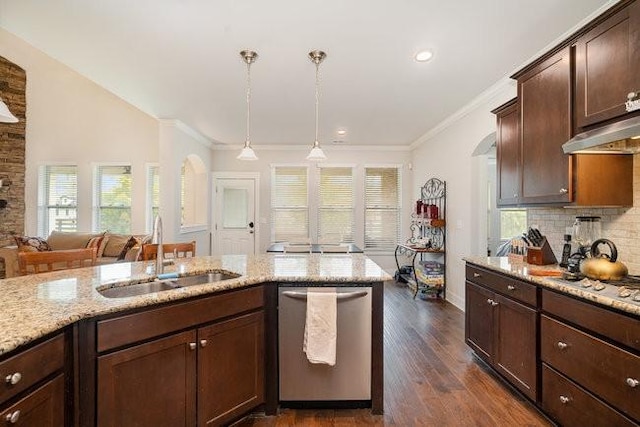 kitchen with appliances with stainless steel finishes, light stone counters, dark wood-type flooring, sink, and hanging light fixtures