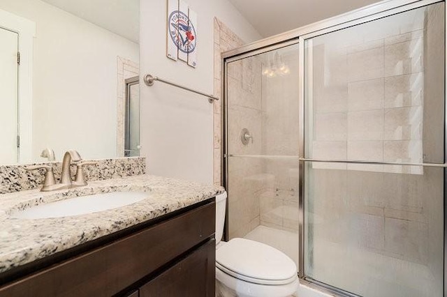 bathroom with vanity, an enclosed shower, and toilet