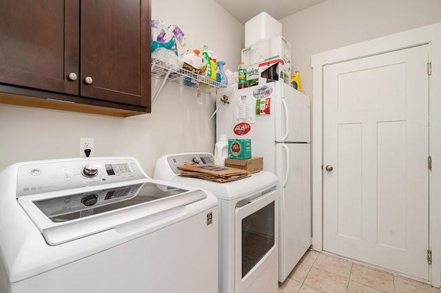 washroom with cabinets, light tile patterned floors, and separate washer and dryer