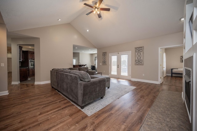 living room with dark hardwood / wood-style flooring, ceiling fan, french doors, and high vaulted ceiling