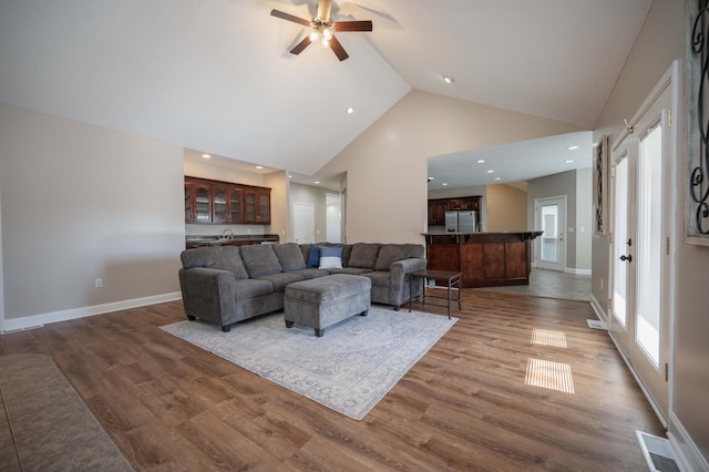 living room with ceiling fan, wood-type flooring, and high vaulted ceiling