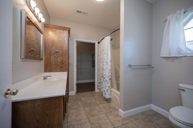 full bathroom featuring tile patterned flooring, shower / bath combination with curtain, a textured ceiling, toilet, and vanity