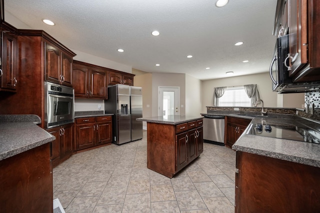 kitchen featuring dark brown cabinetry, sink, black appliances, light tile patterned floors, and a center island