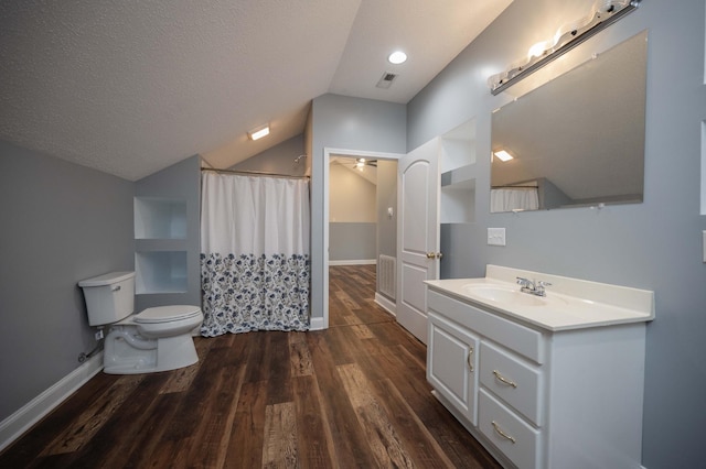 bathroom featuring vanity, lofted ceiling, hardwood / wood-style flooring, toilet, and a textured ceiling