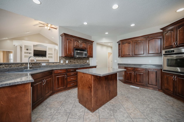 kitchen featuring appliances with stainless steel finishes, backsplash, dark brown cabinets, sink, and lofted ceiling