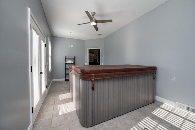 interior space featuring a jacuzzi, ceiling fan, and light tile patterned floors