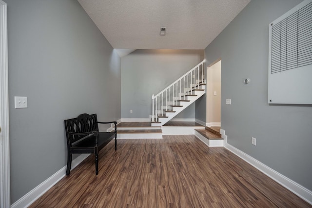 living area with a textured ceiling and dark hardwood / wood-style floors