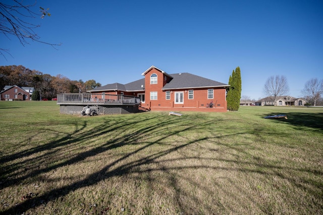 back of property featuring a deck and a lawn