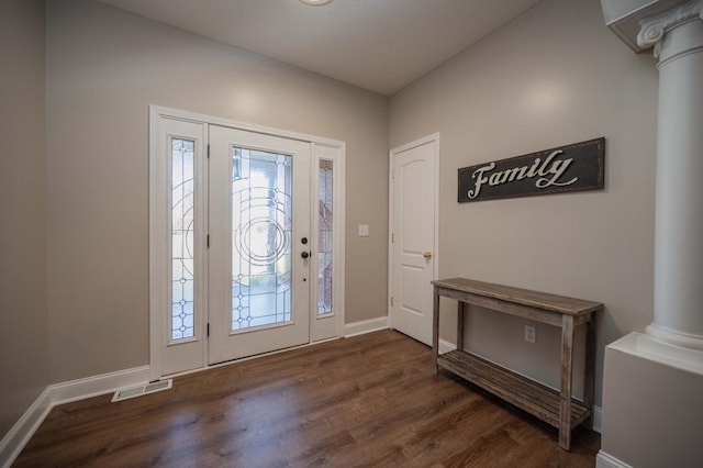 foyer entrance featuring dark hardwood / wood-style floors and decorative columns